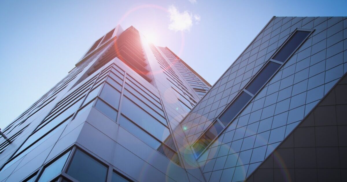 low-angle photography of blue glass walled buildings under blue and white sky